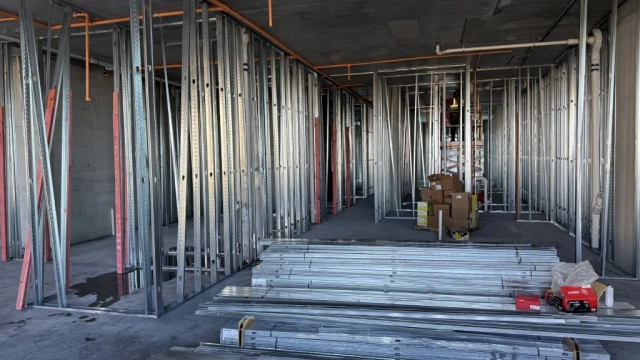 Stacks of metal studs inside unfinished high-rise construction area.