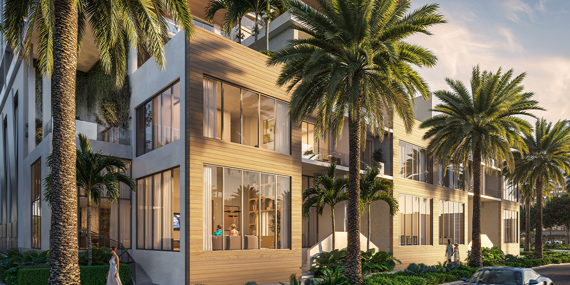 Exterior rendering of a One Park Sarasota townhouse showing warm-toned materials, large glass windows, palm-lined sidewalks, and street activity.