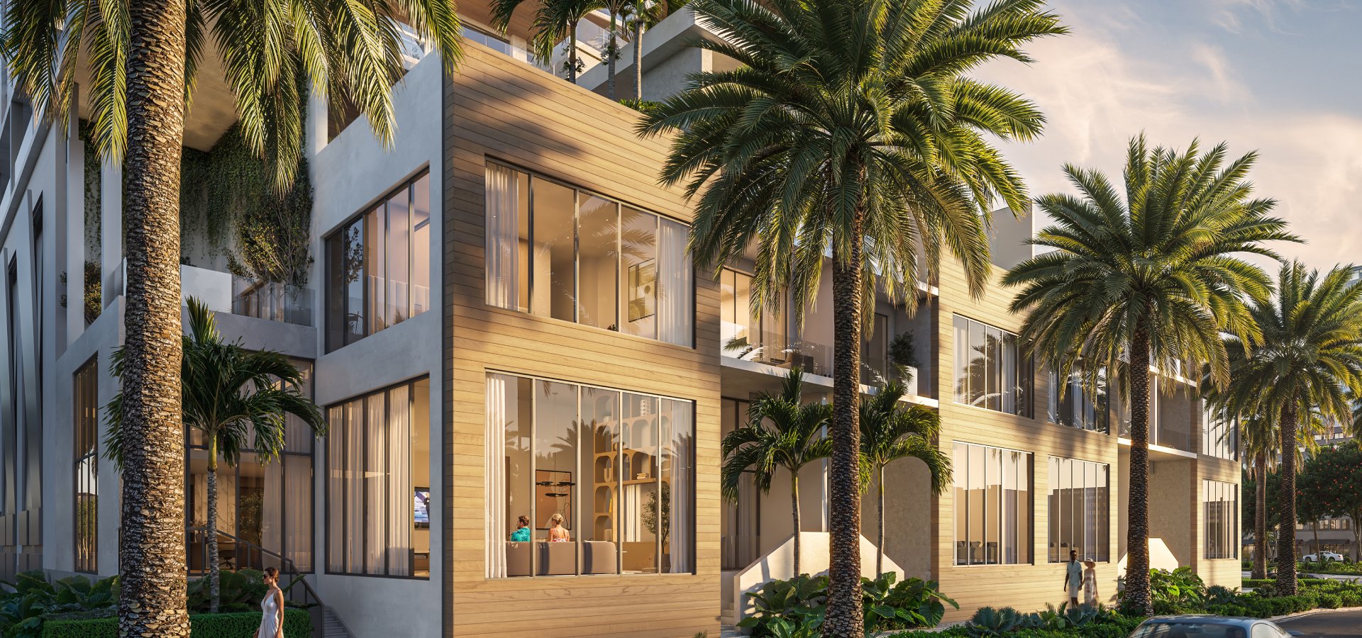 Modern townhouse exterior with large windows and palm trees along sidewalk